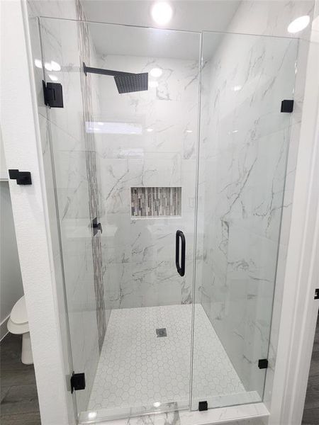 Bathroom with toilet and a marble finish shower Bathroom with toilet and a marble finish shower