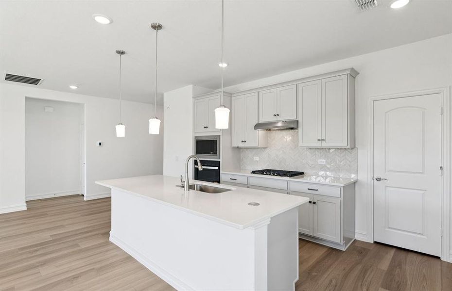 Large island overlooking gathering room and dining areas