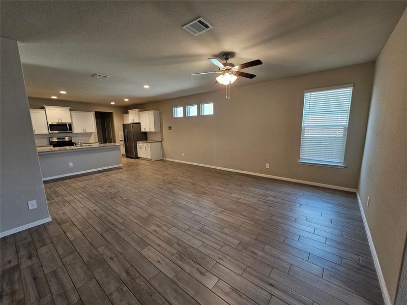 Living area featuring wood looking tile floors, ceiling fan and moldings.