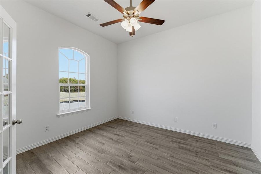 Empty room featuring light wood finished floors and a ceiling fan