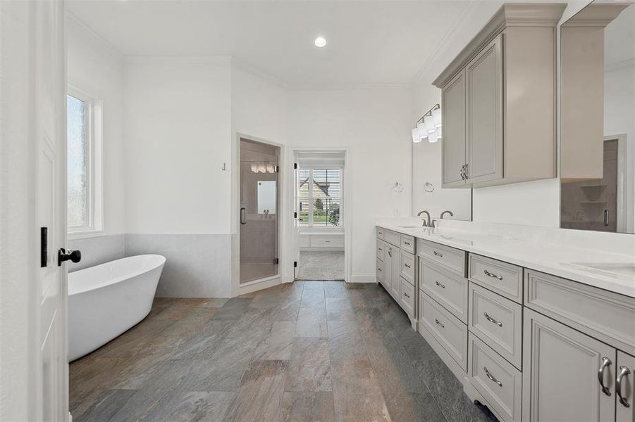 Full bath with double vanity, a freestanding tub, crown molding, a stall shower, and recessed lighting Full bath with double vanity, a freestanding tub, crown molding, a stall shower, and recessed lighting