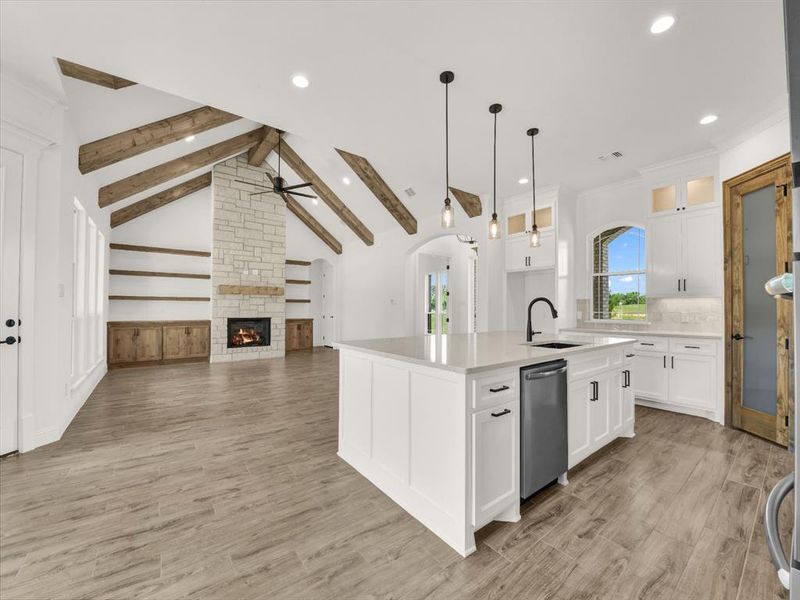 Kitchen with a sink, a ceiling fan, a center island with sink, recessed lighting, and a fireplace Kitchen with a sink, a ceiling fan, a center island with sink, recessed lighting, and a fireplace