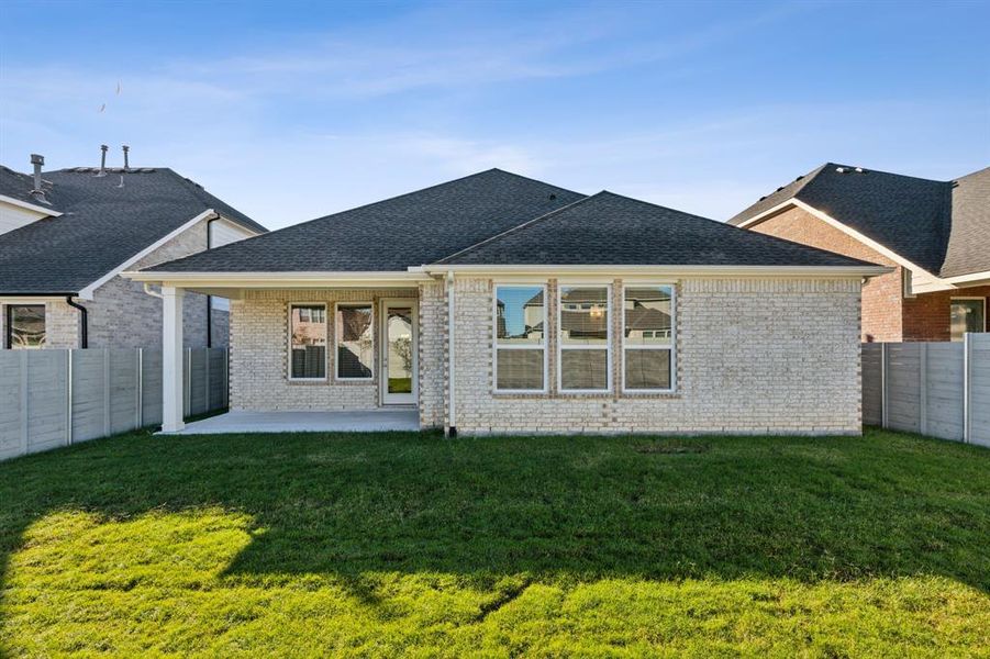 Rear view of house featuring a yard and a patio