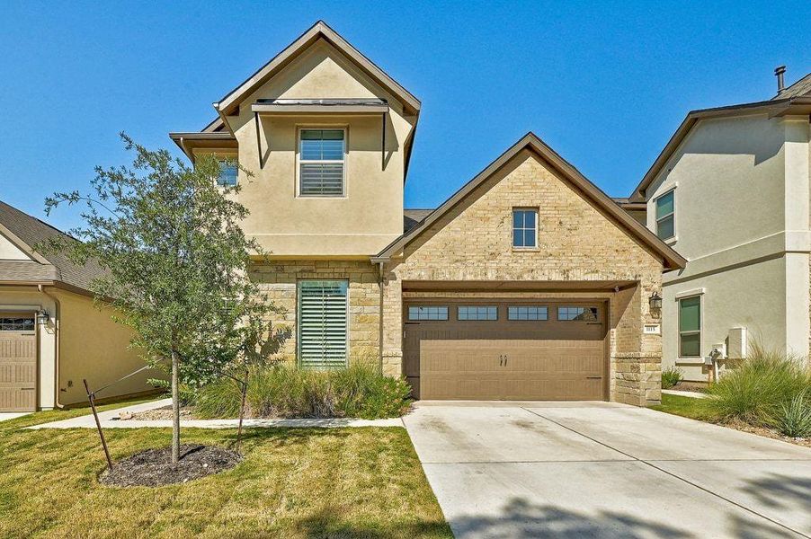 View of front of home featuring stucco siding, driveway, a garage, and stone siding View of front of home featuring stucco siding, driveway, a garage, and stone siding