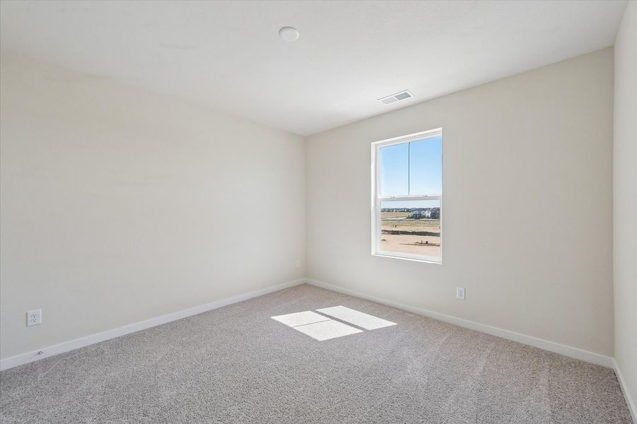 A room with a window and a carpet.