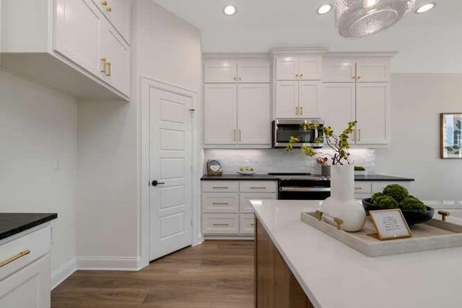 Kitchen featuring light wood-style floors, stainless steel microwave, electric range oven, white cabinets, and recessed lighting Kitchen featuring light wood-style floors, stainless steel microwave, electric range oven, white cabinets, and recessed lighting