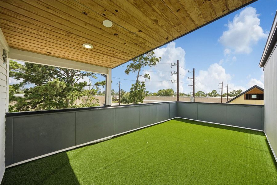 Expansive covered rooftop terrace featuring low-maintenance turf, cedar-plank ceiling, and ample space for outdoor lounging and entertaining. Expansive covered rooftop terrace featuring low-maintenance turf, cedar-plank ceiling, and ample space for outdoor lounging and entertaining.