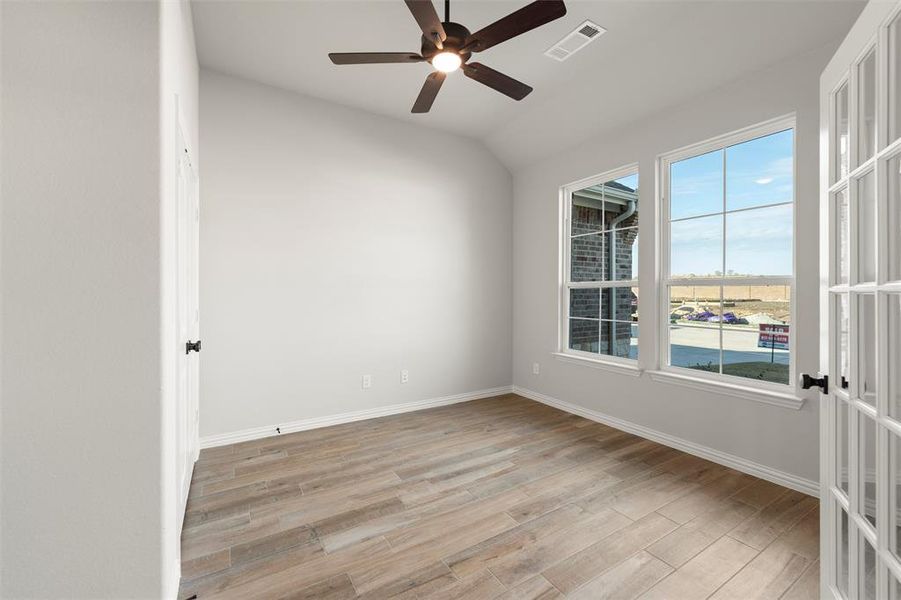 Unfurnished room featuring light wood-type flooring, a ceiling fan, and vaulted ceiling Unfurnished room featuring light wood-type flooring, a ceiling fan, and vaulted ceiling