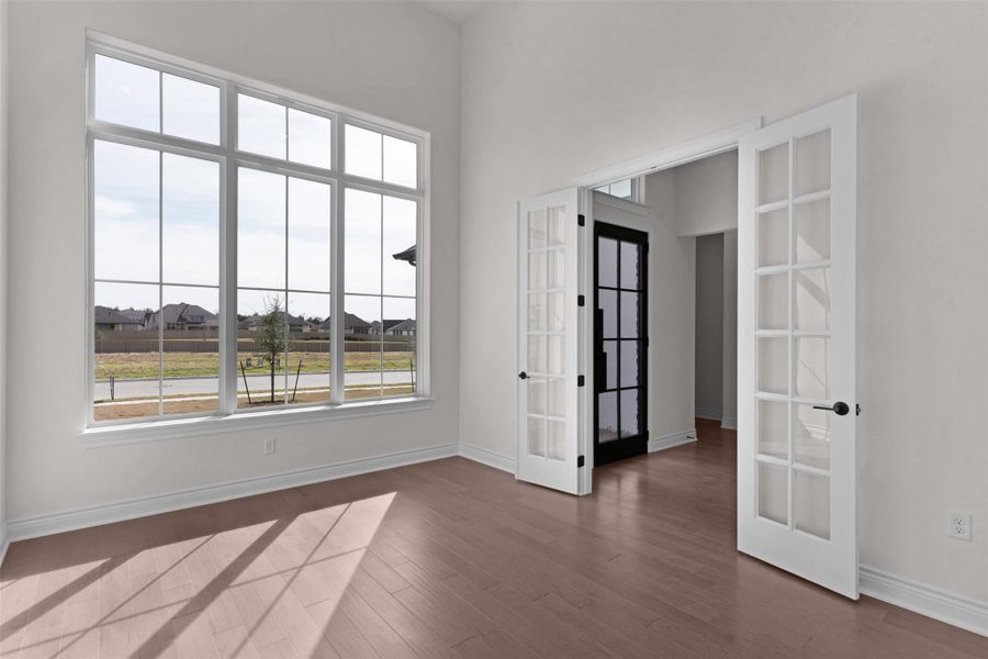 Empty room featuring french doors and dark wood-style flooring
