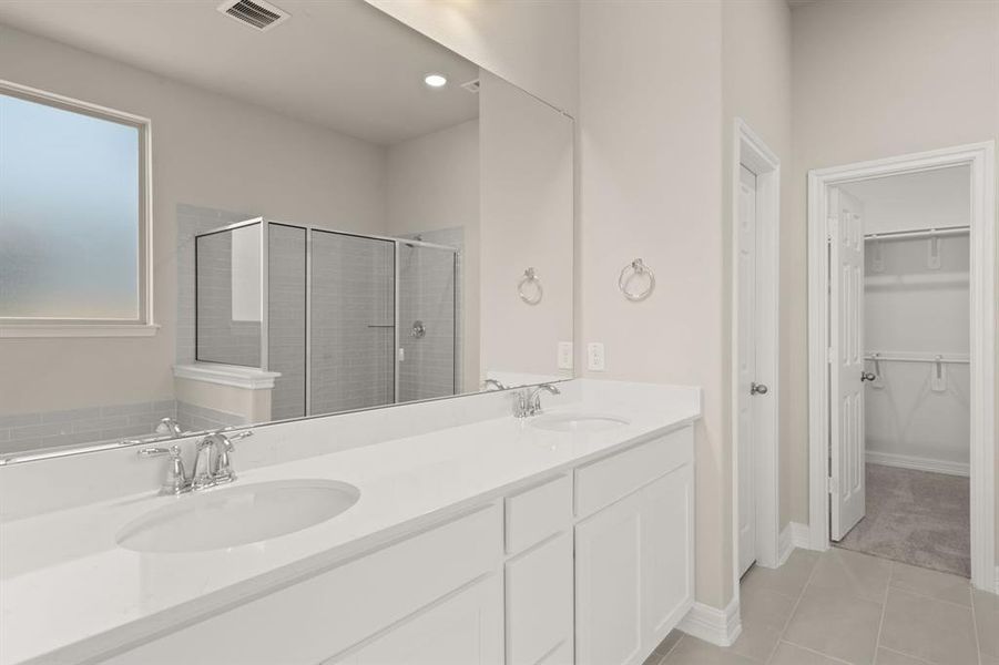 The en-suite bathroom offers a spa-like atmosphere with its elegant design, high end finishes, and tasteful lighting, creating a retreat within your own home.