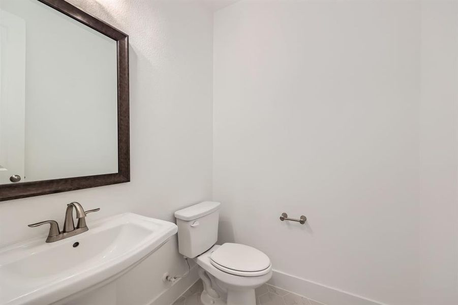 Bathroom featuring tile patterned floors, toilet, and sink