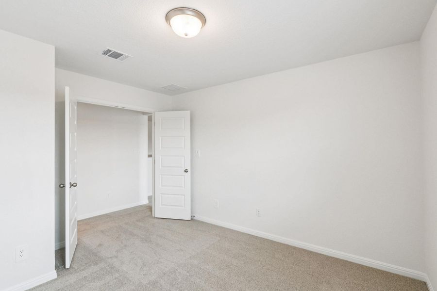 Unfurnished bedroom with light colored carpet and baseboards Unfurnished bedroom with light colored carpet and baseboards
