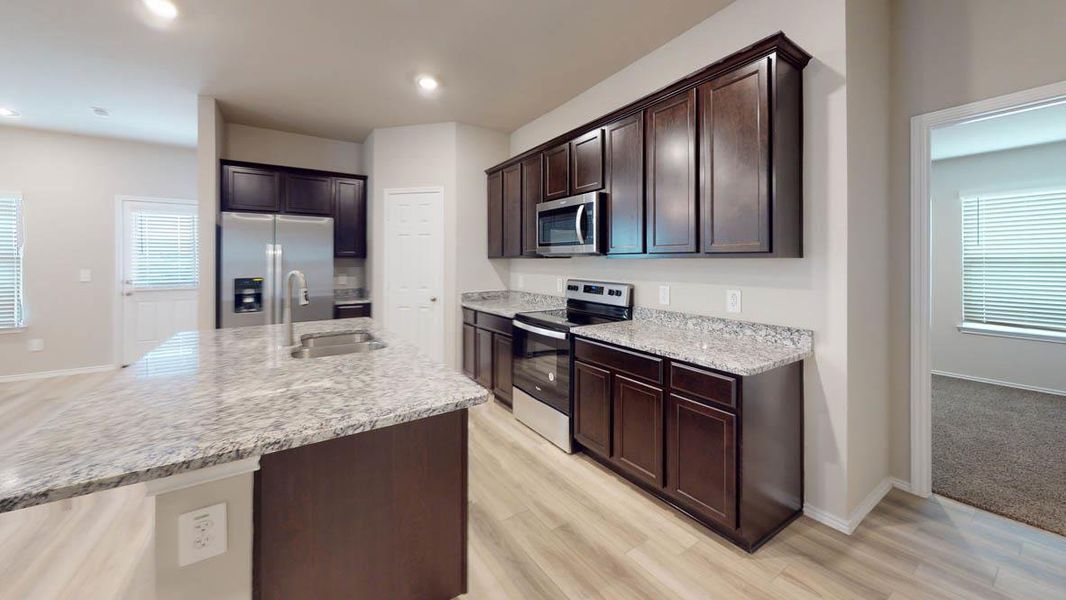 Culinary creations come alive in this kitchen, featuring an island with a sink, sleek stainless steel appliances, and ample counter space. Culinary creations come alive in this kitchen, featuring an island with a sink, sleek stainless steel appliances, and ample counter space.