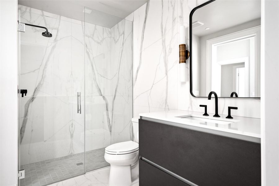 Third ensuite bath featuring Pedini cabinetry, quartz countertops, porcelain floor to ceiling backsplash and designer lighting.