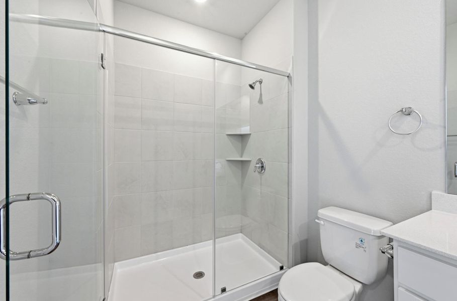Glass-enclosed shower with subway tile surround, integrated shelving, and chrome fixtures Glass-enclosed shower with subway tile surround, integrated shelving, and chrome fixtures