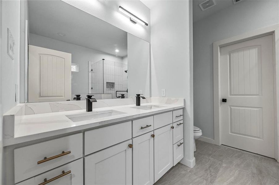 Primary Bathroom with walk in shower, vanity, and toilet