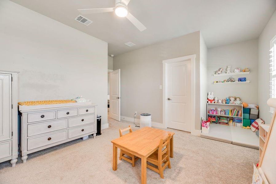 Recreation room with light carpet and a ceiling fan
