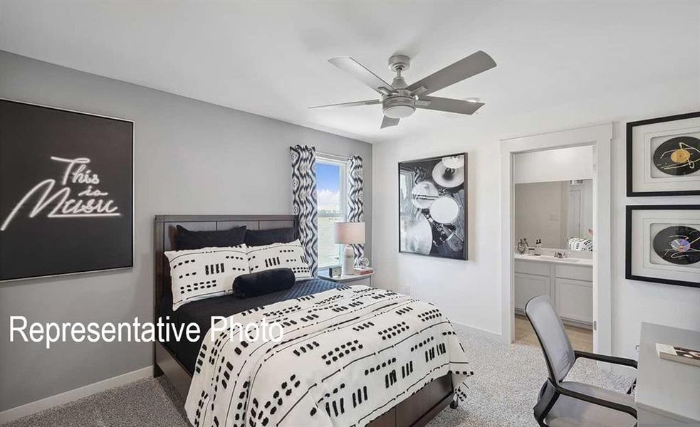 Carpeted bedroom featuring connected bathroom and ceiling fan