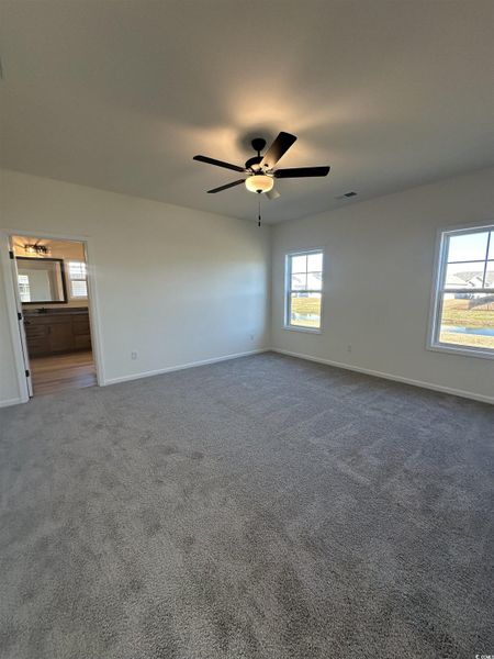 Carpeted spare room featuring baseboards