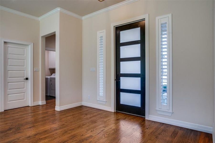 Entrance foyer featuring dark hardwood / wood-style flooring, a wealth of natural light, and ornamental molding