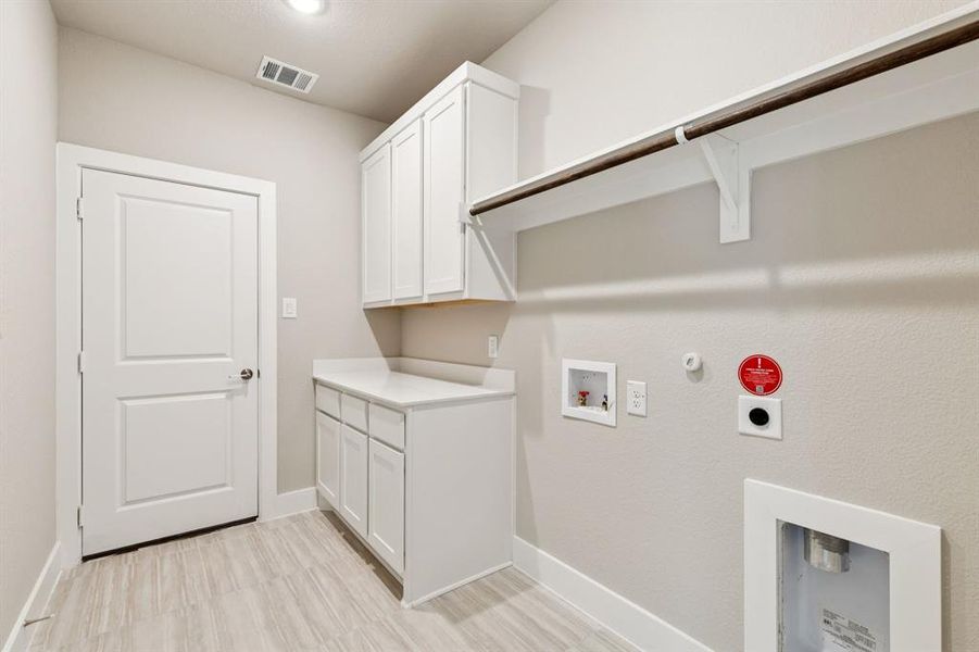Laundry area featuring gas dryer hookup, hookup for a washing machine, cabinet space, and electric dryer hookup