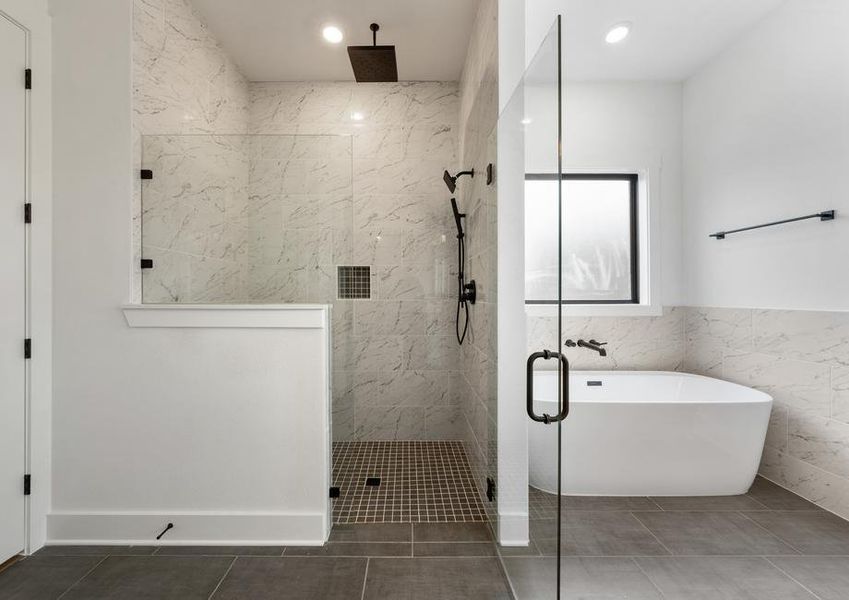 The gorgeous master bathroom has a large glass, walk-in shower and tub.