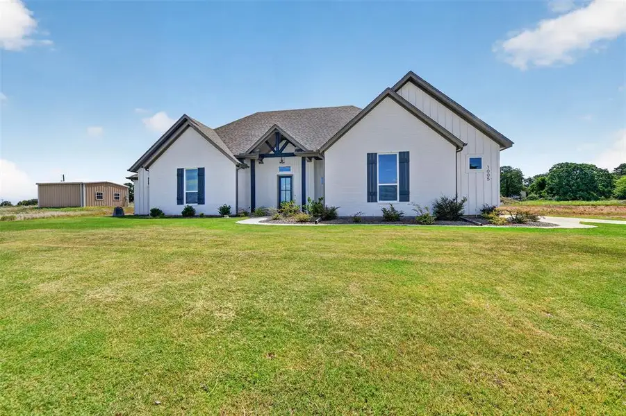 Contemporary ranch-style exterior featuring white siding with dark trim accents and a dark shingle roof Contemporary ranch-style exterior featuring white siding with dark trim accents and a dark shingle roof