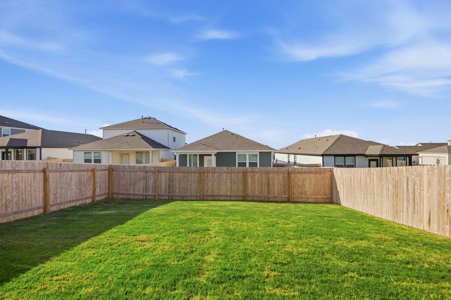 A generously sized yard, securely fenced, offers ample space for outdoor enjoyment.