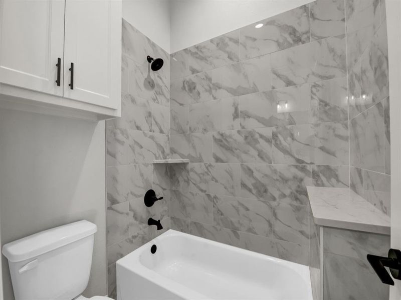 Bathroom featuring toilet and tiled shower / bath