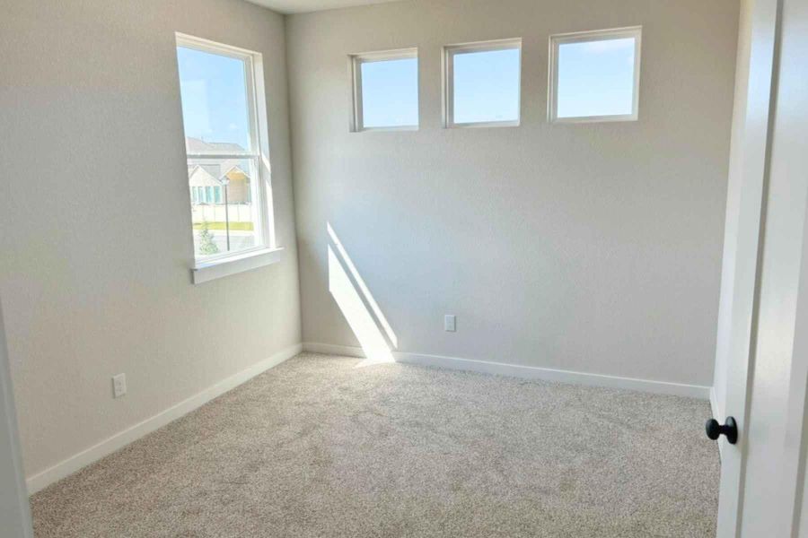 Carpeted empty room with baseboards