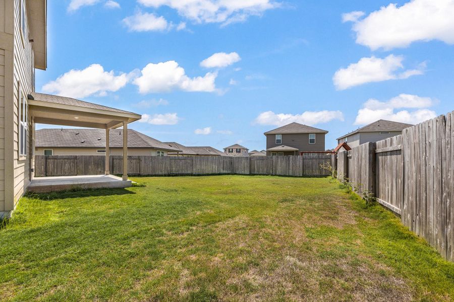 Fenced backyard with a patio and a residential view Fenced backyard with a patio and a residential view