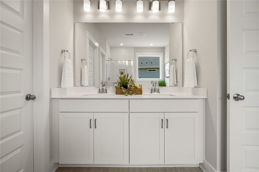 A well-lit bathroom with a double vanity and sleek A well-lit bathroom with a double vanity and sleek