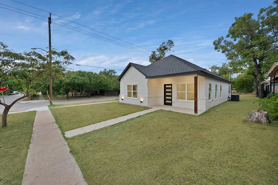 View of home's exterior featuring a yard and roof with shingles
