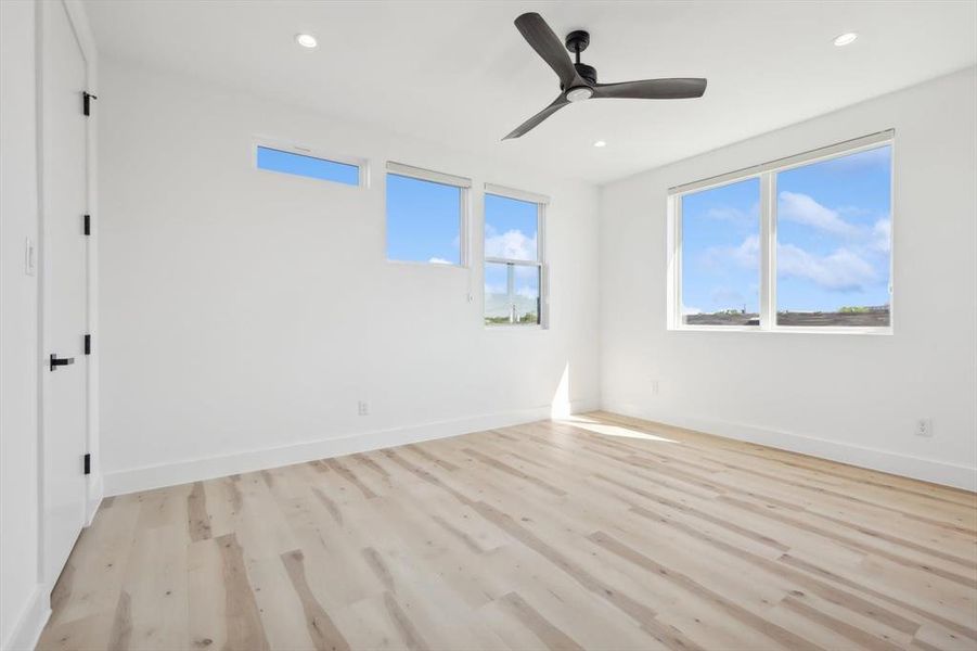 Empty room featuring light wood-type flooring and ceiling fan