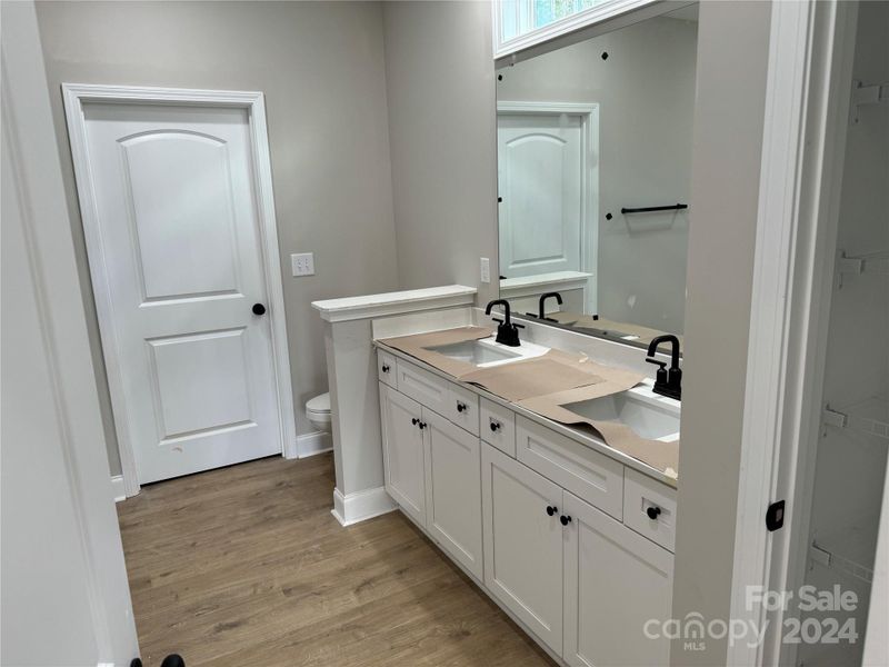 primary bath with two walk in closets and a linen closet