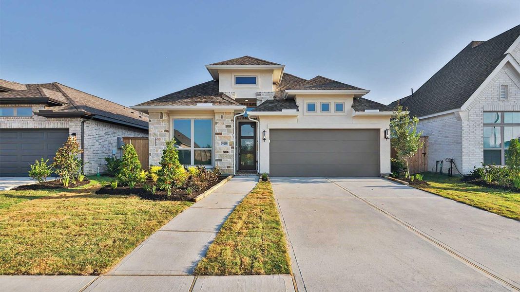 Front exterior of a new home in Valencia, Manvel, TX, highlighting curb appeal (Image 2).