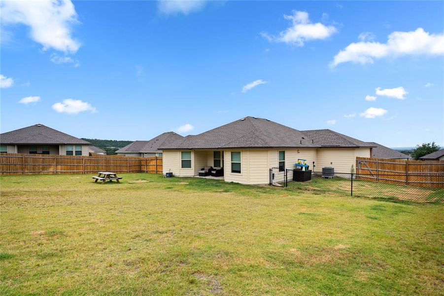 Rear view of house with a patio area and a fenced backyard