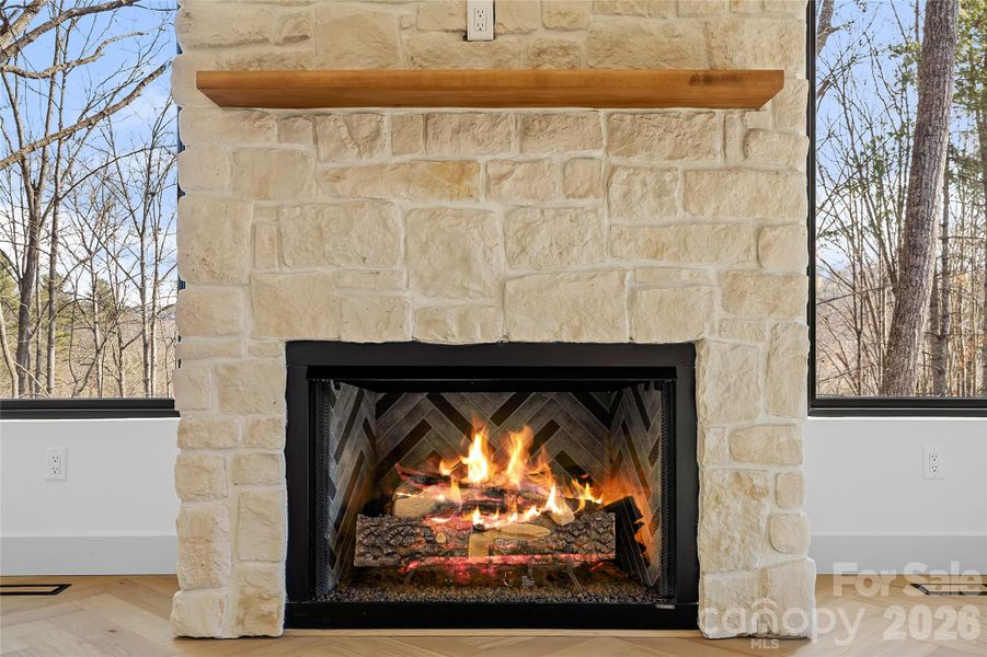 Custom gas fireplace with rough-cut casa blanca cultured stone surround with a white oak mantle