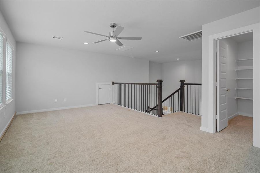 A view of the loft area looking towards the staircase and closet for extra storage.