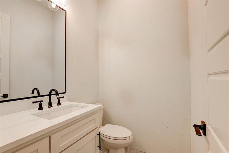 Half bathroom with vanity and tile patterned floors