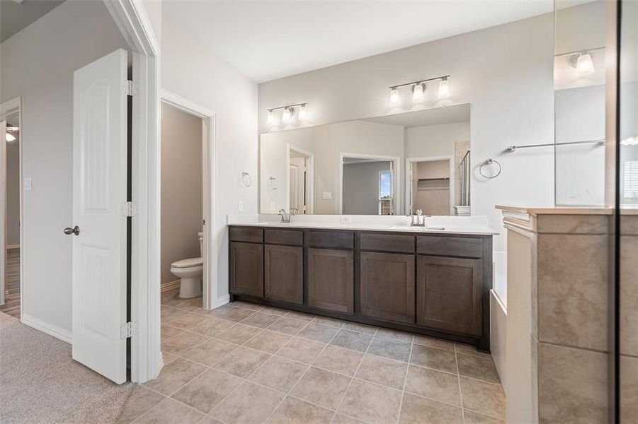 Bathroom featuring double vanity and light tile patterned flooring Bathroom featuring double vanity and light tile patterned flooring