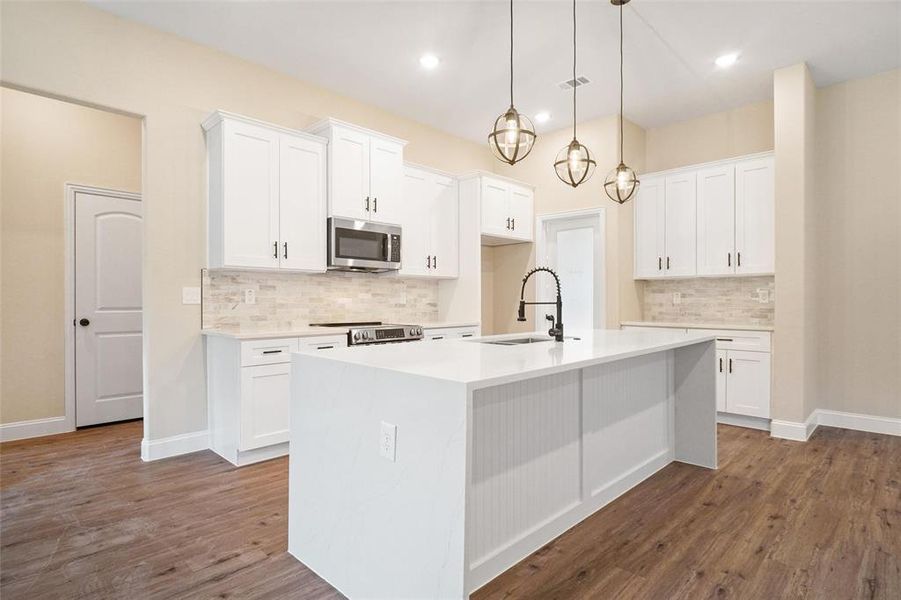 Kitchen featuring appliances with stainless steel finishes, white cabinets, and dark hardwood / wood-style floors