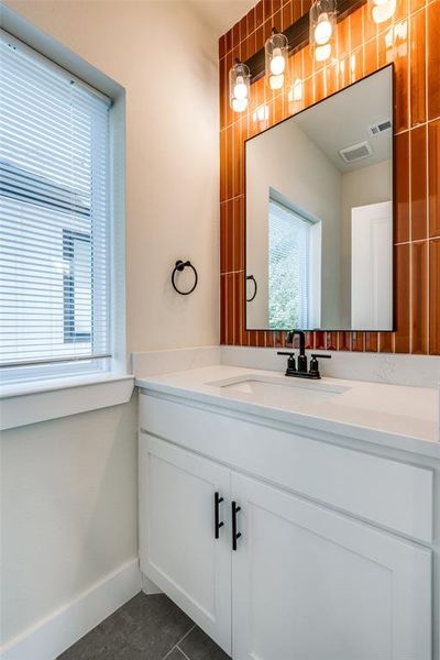 Bathroom with vanity and dark tile patterned floors