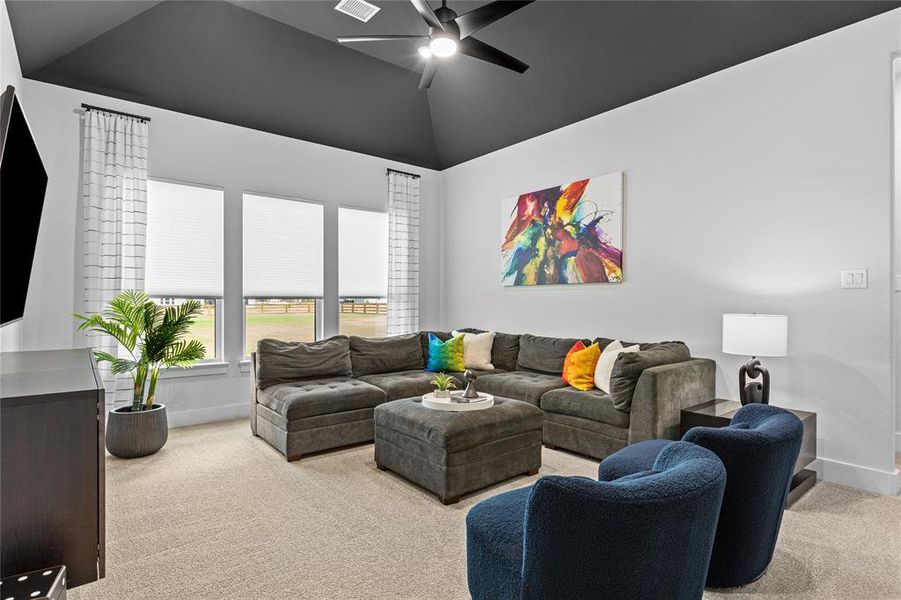 Living room with light carpet, lofted ceiling, and ceiling fan