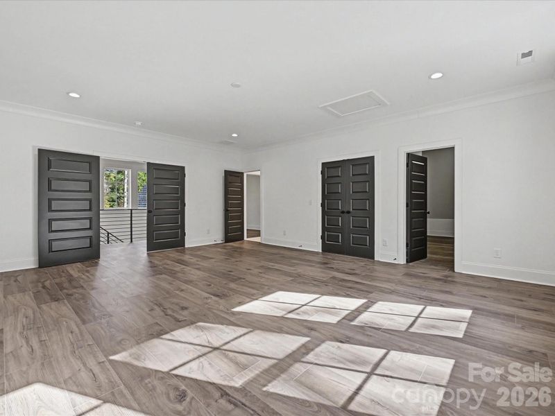 Expansive media room with abundant natural light, modern finishes, and flexible space ideal for a home theater, game room, or additional living area.