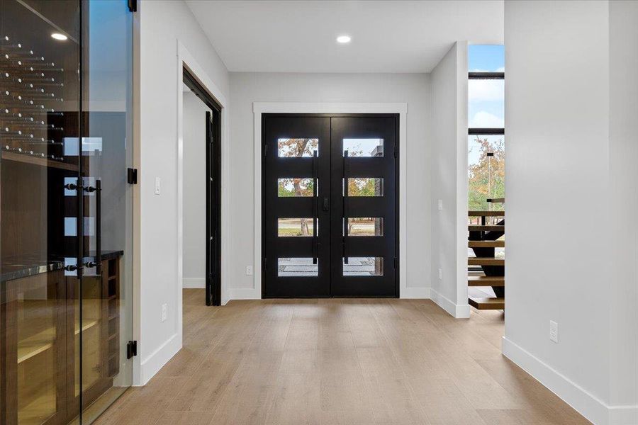 Foyer featuring recessed lighting, light wood- tiled floors, and french doors Foyer featuring recessed lighting, light wood- tiled floors, and french doors