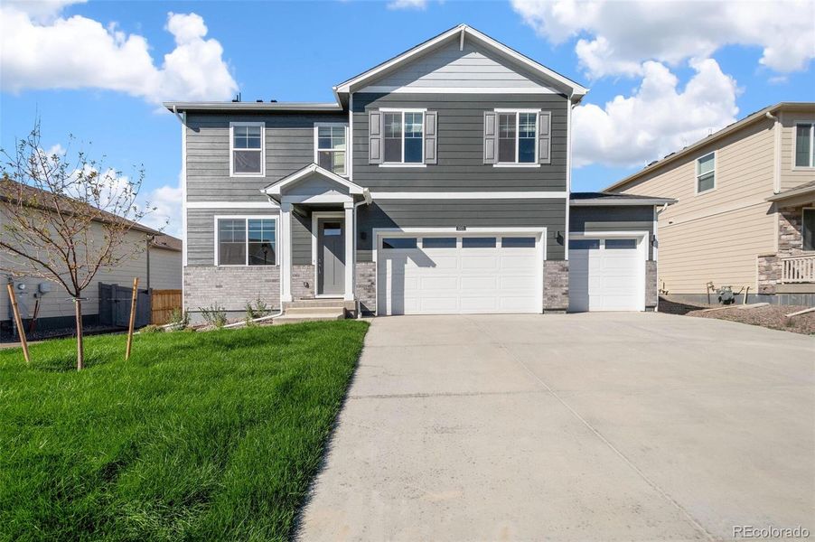 Front exterior of a new home in Brighton Crossing, Brighton, CO, highlighting curb appeal (Image 1).