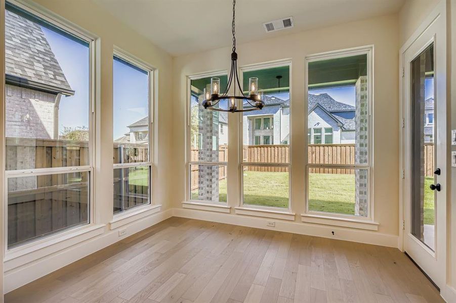 Unfurnished dining area featuring light wood-style flooring and a chandelier