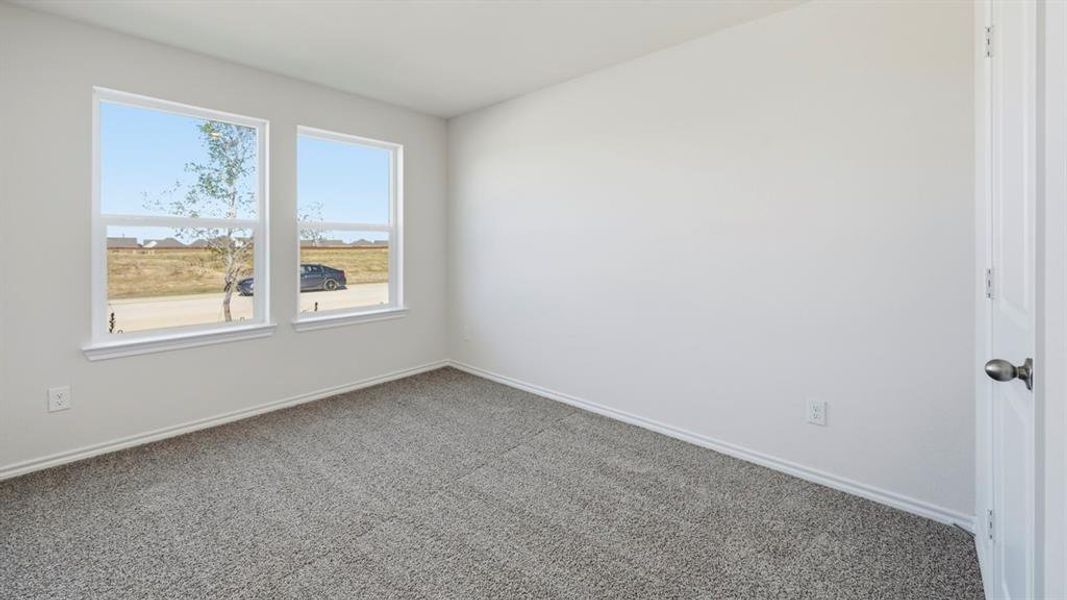 Empty room with carpet flooring and baseboards Empty room with carpet flooring and baseboards