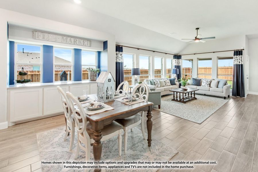 Open-plan dining and living area with wood-look tile floors, vaulted ceiling, and large windows with blue curtains